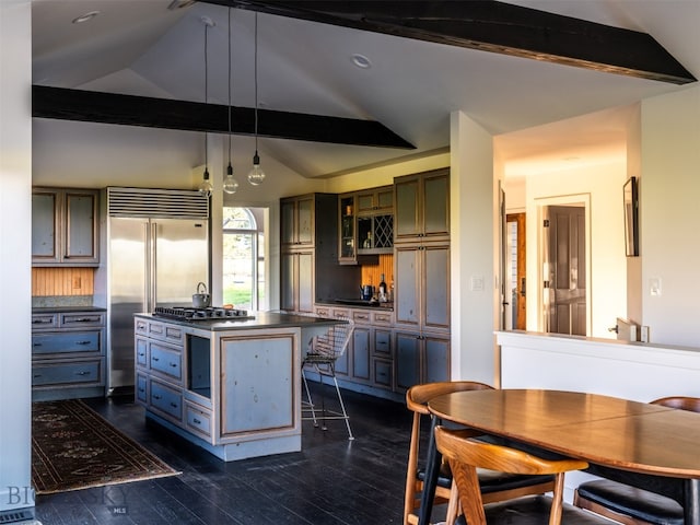 370 Star Ridge Rd, Bozeman, MT 59715 - kitchen with dark countertops, vaulted ceiling, appliances with stainless steel finishes, dark wood-type flooring, and a center island