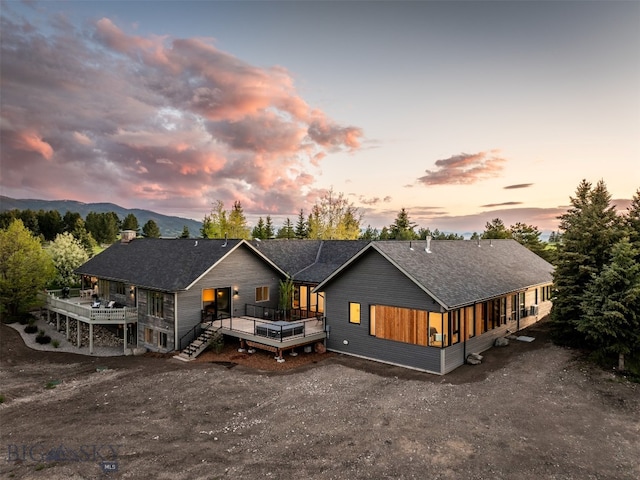 370 Star Ridge Rd, Bozeman, MT 59715 - back of house at dusk featuring a deck and a chimney
