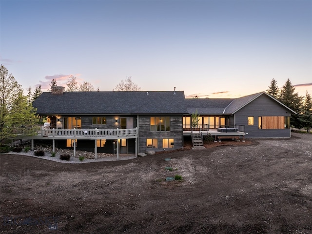 370 Star Ridge Rd, Bozeman, MT 59715 - back of property at dusk with a deck, a chimney, and a shingled roof
