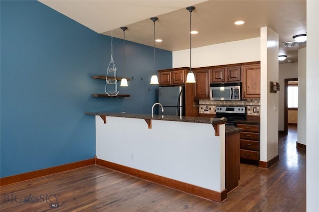 4364 Brookside Ln, Bozeman, MT 59718 - kitchen featuring stainless steel appliances, a breakfast bar area, dark wood finished floors, and tasteful backsplash
