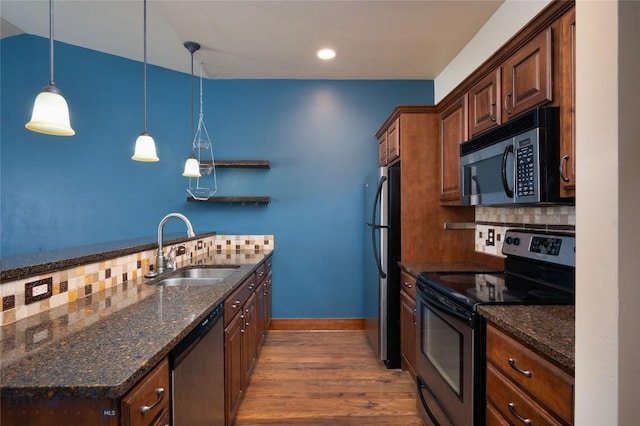 4364 Brookside Ln, Bozeman, MT 59718 - kitchen featuring appliances with stainless steel finishes, a sink, backsplash, wood finished floors, and dark stone countertops