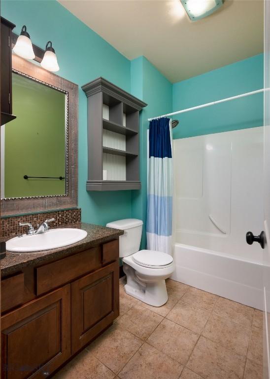 4364 Brookside Ln, Bozeman, MT 59718 - bathroom with toilet, vanity, shower / bathtub combination with curtain, backsplash, and tile patterned flooring