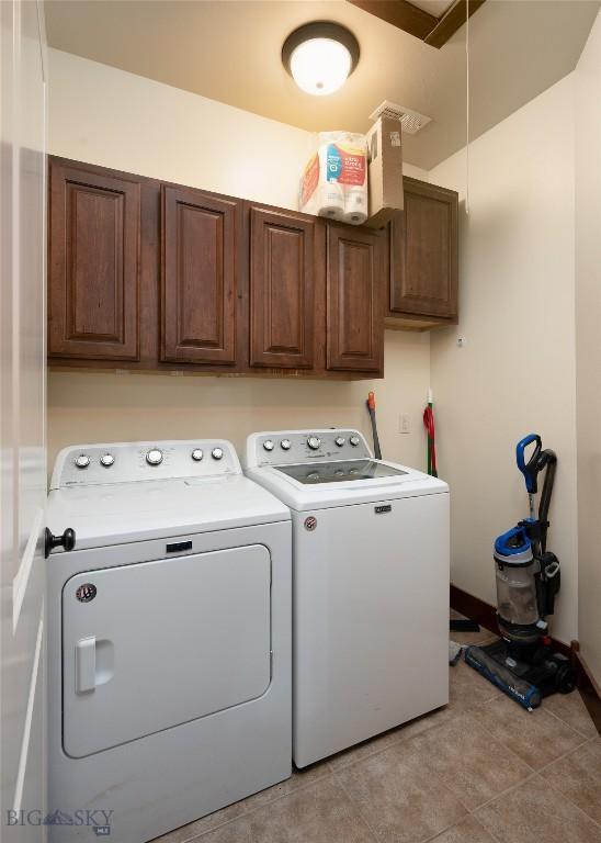 4364 Brookside Ln, Bozeman, MT 59718 - laundry area with cabinet space, washing machine and dryer, light tile patterned floors, and baseboards