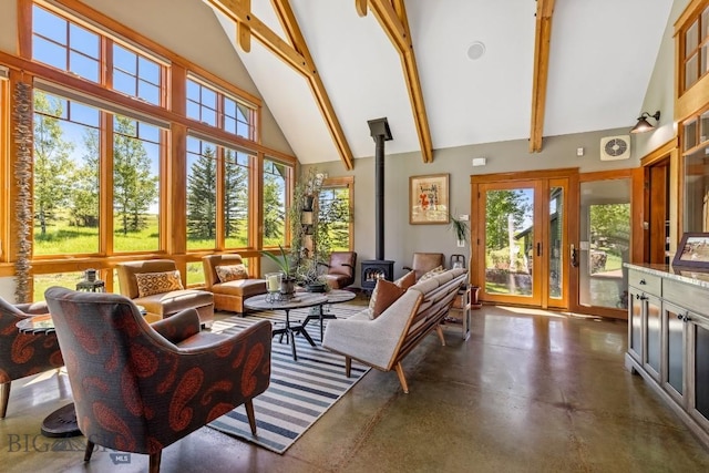 2594 Star Ridge Rd, Bozeman, MT 59715 - living area featuring high vaulted ceiling, a wood stove, finished concrete flooring, beamed ceiling, and plenty of natural light