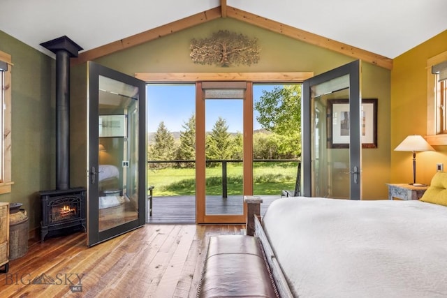 2594 Star Ridge Rd, Bozeman, MT 59715 - bedroom with a wood stove, hardwood / wood-style flooring, access to outside, and vaulted ceiling