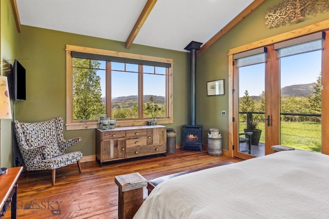 2594 Star Ridge Rd, Bozeman, MT 59715 - bedroom featuring a wood stove, access to outside, multiple windows, and wood-type flooring