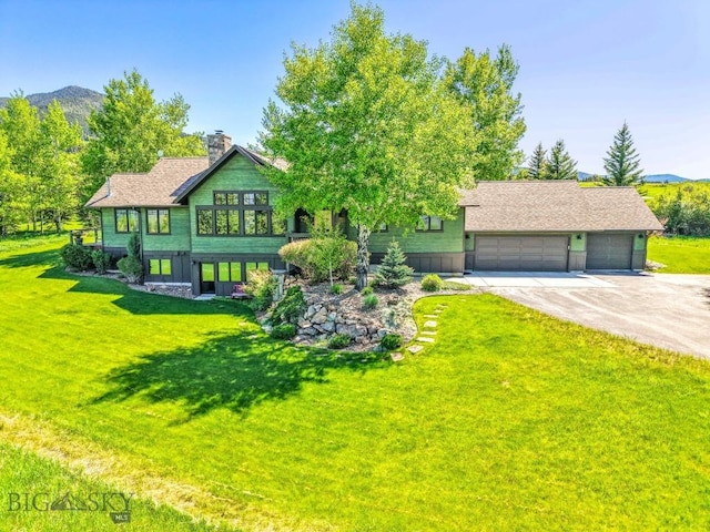 2594 Star Ridge Rd, Bozeman, MT 59715 - view of front facade featuring concrete driveway, a front yard, a garage, and a chimney