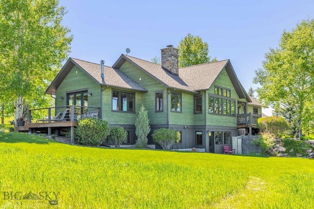 2594 Star Ridge Rd, Bozeman, MT 59715 - rear view of house featuring a chimney, a deck, a shingled roof, and a yard