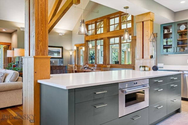 2594 Star Ridge Rd, Bozeman, MT 59715 - kitchen featuring gray cabinets, stainless steel oven, glass insert cabinets, pendant lighting, and healthy amount of natural light
