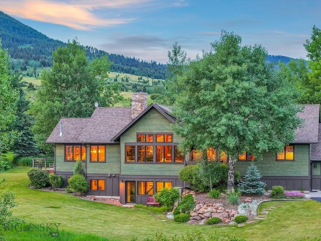 2594 Star Ridge Rd, Bozeman, MT 59715 - back of house with a lawn, a chimney, a shingled roof, and a view of trees
