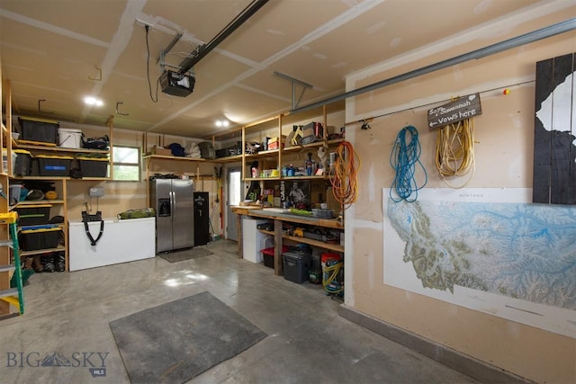 975 Jessie Way, Bozeman, MT 59715 - garage featuring stainless steel refrigerator with ice dispenser, a garage door opener, and a workshop area