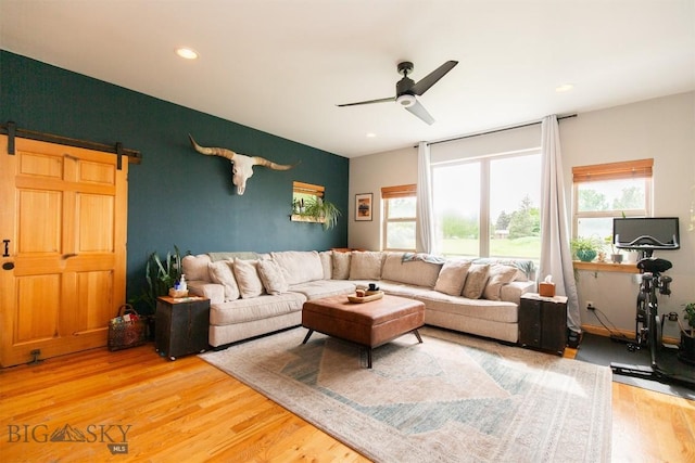 975 Jessie Way, Bozeman, MT 59715 - living room featuring wood finished floors, ceiling fan, a barn door, an accent wall, and recessed lighting
