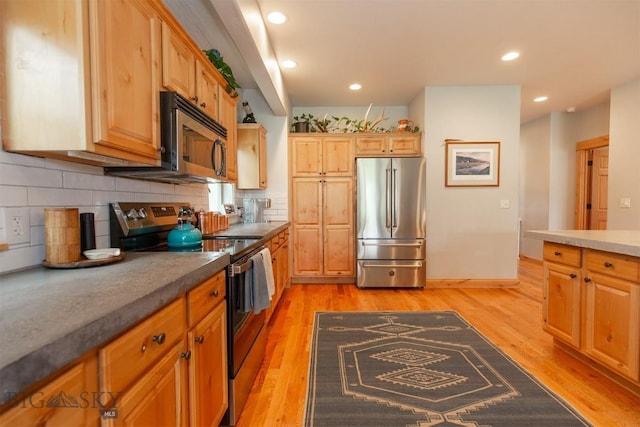 975 Jessie Way, Bozeman, MT 59715 - kitchen featuring appliances with stainless steel finishes, light wood-style flooring, backsplash, and recessed lighting