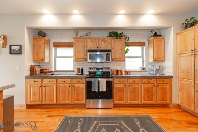 975 Jessie Way, Bozeman, MT 59715 - kitchen with appliances with stainless steel finishes, dark countertops, plenty of natural light, and recessed lighting