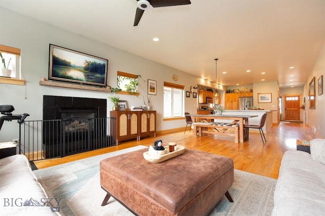 975 Jessie Way, Bozeman, MT 59715 - living room featuring ceiling fan, light wood-type flooring, a tiled fireplace, recessed lighting, and baseboards