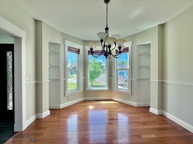 2475 Rose St, Bozeman, MT 59718 - unfurnished dining area featuring hardwood / wood-style flooring, a chandelier, healthy amount of natural light, and built in shelves