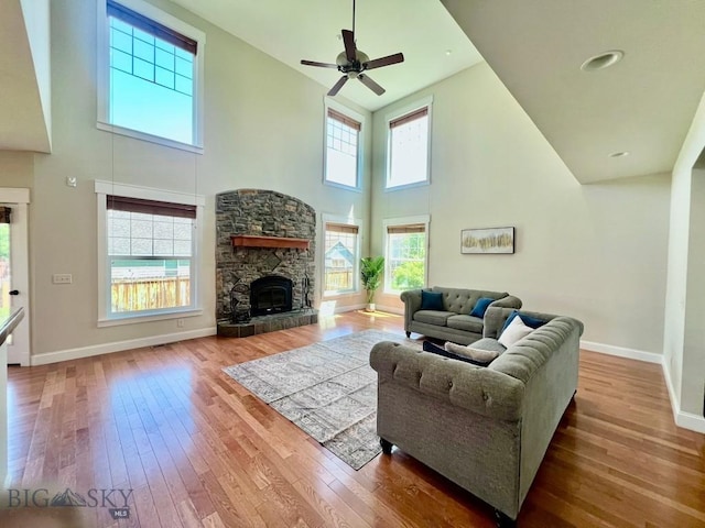 2475 Rose St, Bozeman, MT 59718 - living area with a high ceiling, wood-type flooring, a ceiling fan, and a stone fireplace
