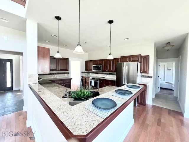 2475 Rose St, Bozeman, MT 59718 - kitchen featuring appliances with stainless steel finishes, dark brown cabinetry, tasteful backsplash, light wood finished floors, and recessed lighting