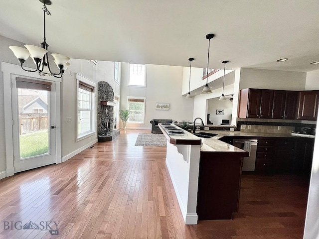 2475 Rose St, Bozeman, MT 59718 - kitchen with stainless steel dishwasher, dark brown cabinetry, hardwood / wood-style flooring, and a chandelier