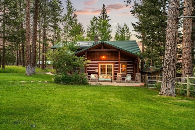 1561/1563 Colorado Gulch Dr, Helena, MT 59601 - back of property at dusk featuring a chimney, a metal roof, and a patio