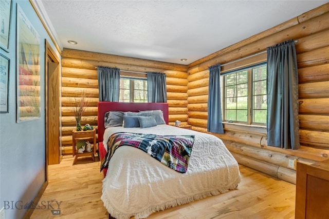 1561/1563 Colorado Gulch Dr, Helena, MT 59601 - bedroom featuring multiple windows, light wood finished floors, log walls, a textured ceiling, and recessed lighting