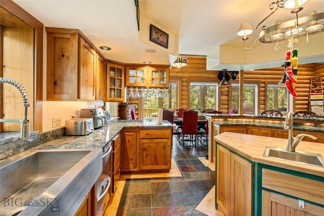 1561/1563 Colorado Gulch Dr, Helena, MT 59601 - kitchen with rustic walls, a peninsula, brown cabinets, dark stone finish floors, and glass insert cabinets