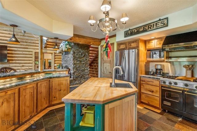1561/1563 Colorado Gulch Dr, Helena, MT 59601 - kitchen with log walls, butcher block countertops, appliances with stainless steel finishes, wall chimney range hood, and a chandelier