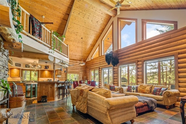 1561/1563 Colorado Gulch Dr, Helena, MT 59601 - living room with high vaulted ceiling, a wooden ceiling with exposed beams, ceiling fan, dark stone finish flooring, and rustic walls