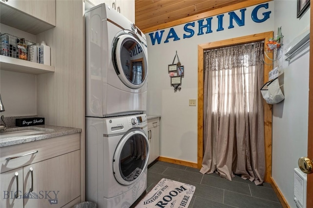 1561/1563 Colorado Gulch Dr, Helena, MT 59601 - laundry area featuring stacked washer / dryer, cabinet space, and dark tile patterned flooring