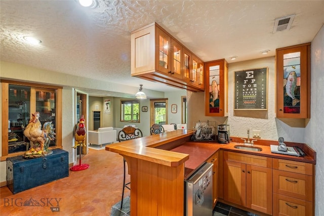 1561/1563 Colorado Gulch Dr, Helena, MT 59601 - kitchen featuring stainless steel dishwasher, wood counters, a breakfast bar area, glass insert cabinets, and a peninsula