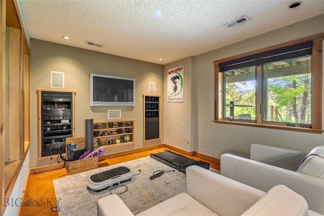 1561/1563 Colorado Gulch Dr, Helena, MT 59601 - cinema featuring beverage cooler, a textured ceiling, wood finished floors, and recessed lighting