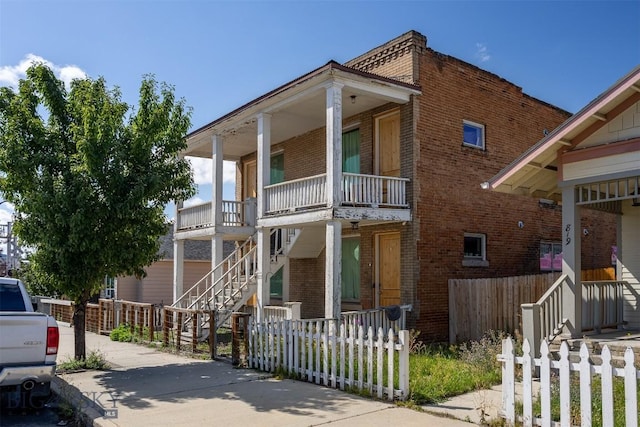 823 S Main, Butte, MT 59701 - view of front facade with brick siding, stairs, a fenced front yard, and covered porch