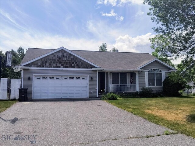 1006 E Missoula, Belgrade, MT 59714 - single story home with asphalt driveway, an attached garage, a front yard, and a porch