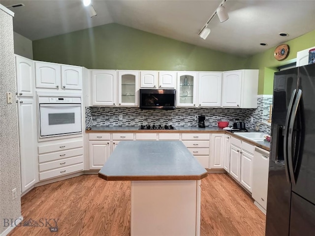 1006 E Missoula, Belgrade, MT 59714 - kitchen with black appliances, a sink, vaulted ceiling, light wood finished floors, and rail lighting