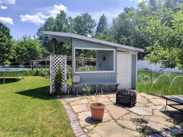 1006 E Missoula, Belgrade, MT 59714 - view of patio with a fire pit, an outdoor structure, and a trampoline