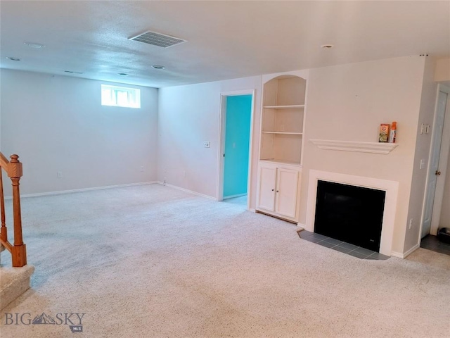1006 E Missoula, Belgrade, MT 59714 - unfurnished living room with carpet flooring, a fireplace with flush hearth, built in shelves, and baseboards