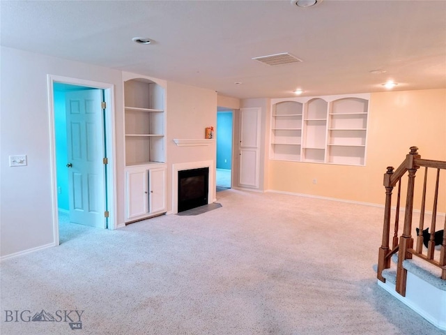 1006 E Missoula, Belgrade, MT 59714 - unfurnished living room with built in features, carpet flooring, a fireplace with flush hearth, baseboards, and recessed lighting