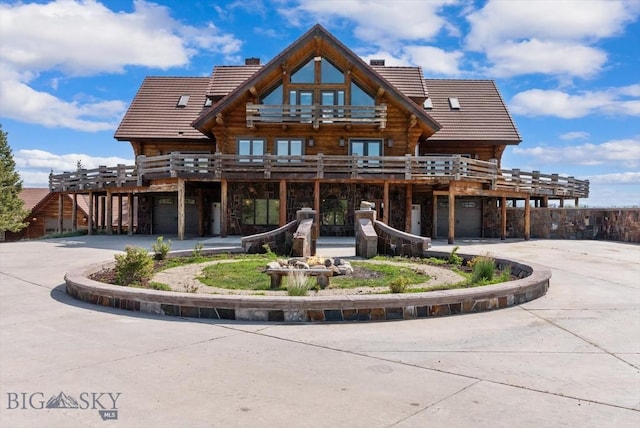 1380 Glacier View Dr, Deer Lodge, MT 59722 - back of property with a tile roof, log siding, stone siding, and curved driveway
