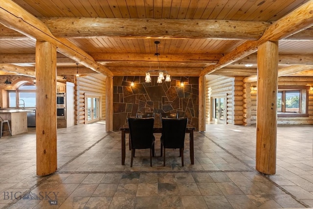 1380 Glacier View Dr, Deer Lodge, MT 59722 - dining space with rustic walls, a chandelier, wood ceiling with exposed beams, and stone tile floors