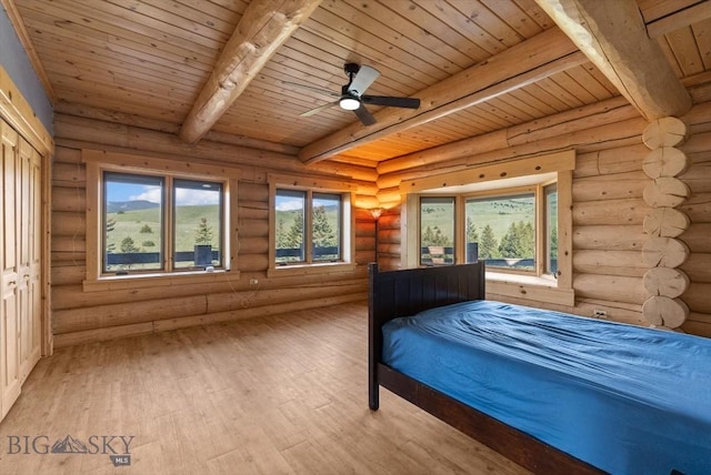 1380 Glacier View Dr, Deer Lodge, MT 59722 - bedroom with light wood-style floors, wood ceiling with exposed beams, rustic walls, and multiple windows