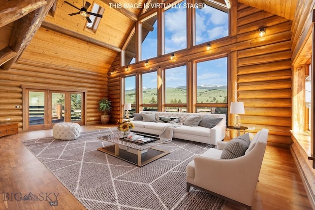 1380 Glacier View Dr, Deer Lodge, MT 59722 - living room with high vaulted ceiling, wooden ceiling with exposed beams, rustic walls, wood finished floors, and healthy amount of natural light