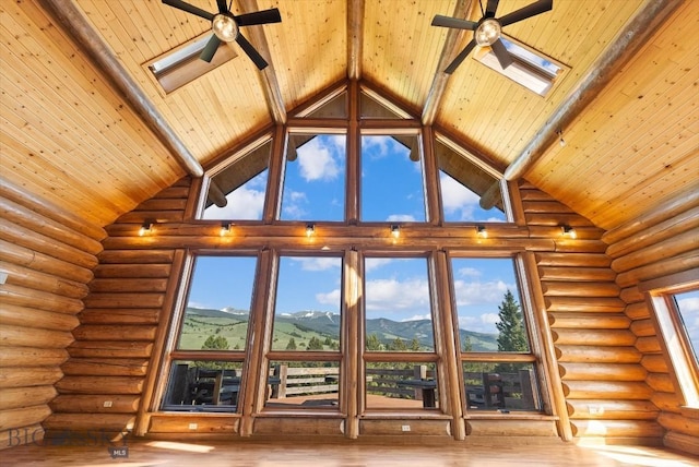1380 Glacier View Dr, Deer Lodge, MT 59722 - detailed view of ceiling fan, wooden ceiling with exposed beams, wood finished floors, log walls, and a mountainous background