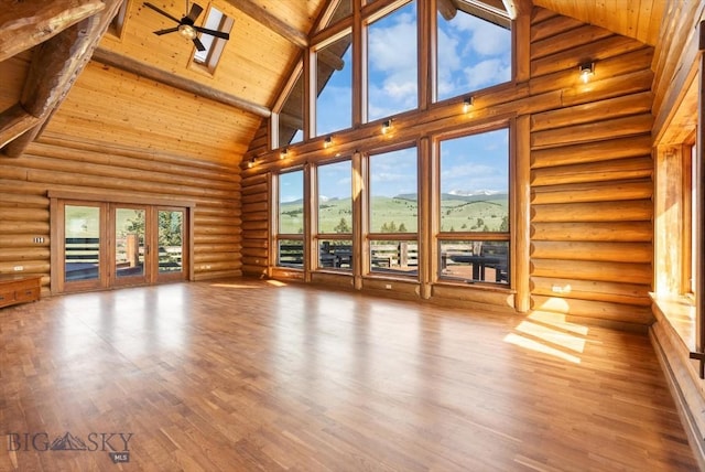 1380 Glacier View Dr, Deer Lodge, MT 59722 - unfurnished living room featuring high vaulted ceiling, wooden ceiling with exposed beams, log walls, a skylight, and wood finished floors