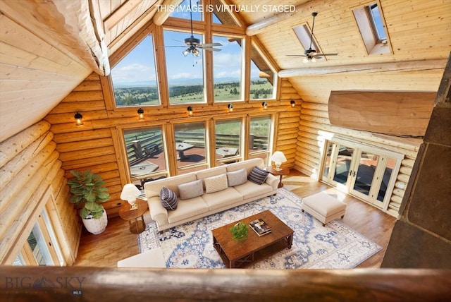 1380 Glacier View Dr, Deer Lodge, MT 59722 - living area featuring rustic walls, healthy amount of natural light, a ceiling fan, high vaulted ceiling, and wood finished floors