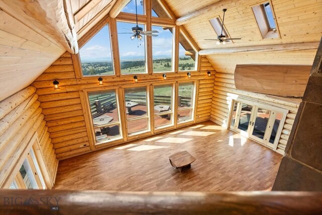 1380 Glacier View Dr, Deer Lodge, MT 59722 - unfurnished living room with log walls, plenty of natural light, wood finished floors, high vaulted ceiling, and a ceiling fan