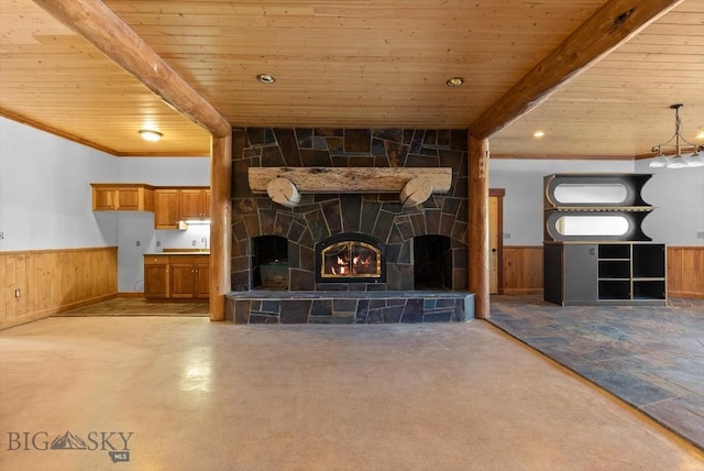 1380 Glacier View Dr, Deer Lodge, MT 59722 - unfurnished living room with wooden ceiling with exposed beams, wooden walls, a wainscoted wall, and a tile fireplace