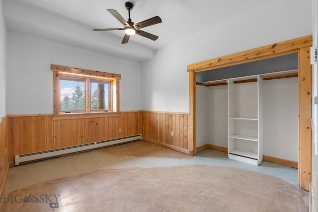 1380 Glacier View Dr, Deer Lodge, MT 59722 - unfurnished bedroom with a baseboard heating unit, wood walls, wainscoting, carpet floors, and ceiling fan