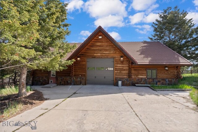 1380 Glacier View Dr, Deer Lodge, MT 59722 - log home featuring an attached garage, driveway, and stone siding