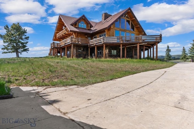 1380 Glacier View Dr, Deer Lodge, MT 59722 - view of front of house with log siding and a wooden deck