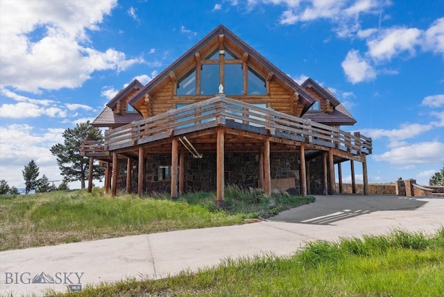 1380 Glacier View Dr, Deer Lodge, MT 59722 - back of property featuring log siding, a wooden deck, and stone siding